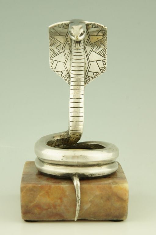 A silvered bronze cobra watch holder on a marble base signed by G. Rischmann.