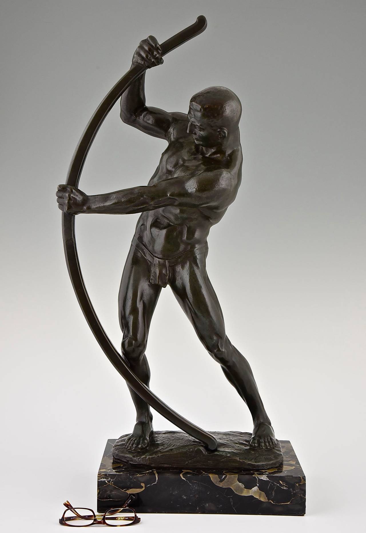 Description:  Sculpture of a male nude with a bow. 
Artist: Adolf Muller Crefeld (German, 1863-1934).
Signature: Muller Crefeld, Berlin.
Style:  Art Deco. 
Date: 1920. 
Material: Patinated bronze (very dark green, almost black)  marble base.