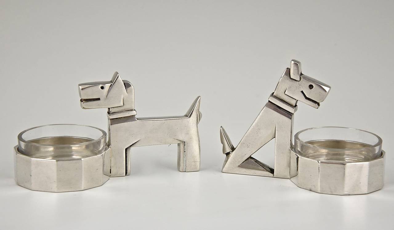 A pair of Art Deco salt cellars in the shape of a sitting and a standing fox terrier after the book “Ric & Rac.”
By Gallia, Christofle. 
Signature and marks:  Gallia stamped mark.  Modelnumber 5988 and 5987.
Style:  Art Deco. 
Date:  1930.