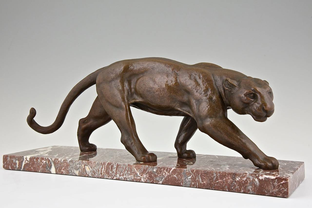 Art Deco bronze of a walking panther. 
Artist: Ouline, Alexandre. Worked in France 1918-1940.
Signature: Ouline. 
Style:  Art Deco. 
Date:  1930.

Material:  Bronze with brown patina.  Marble base. 
Origin:  France. 
Size: 
L. 22 inch x H.