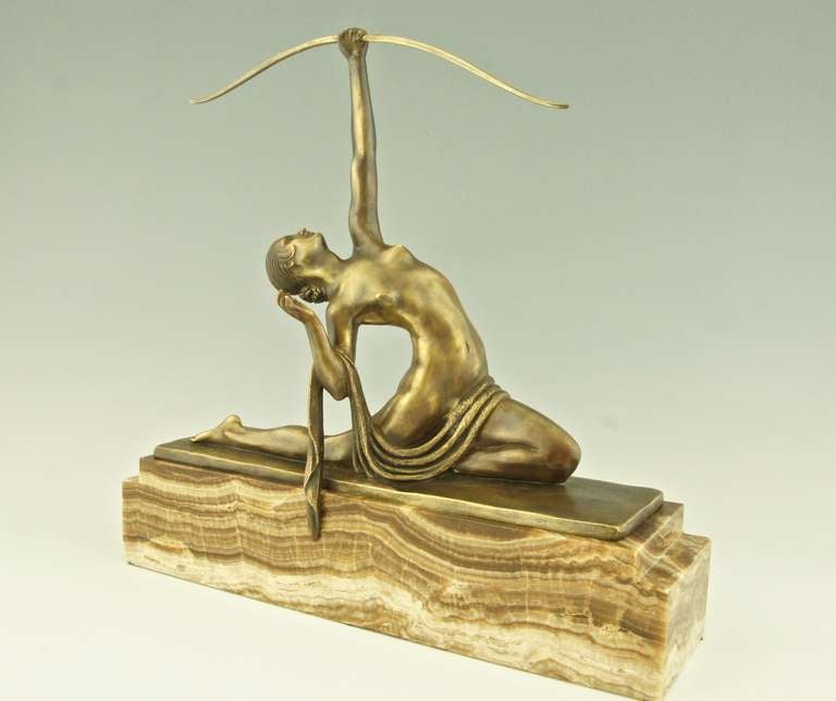 Female archer. 
A bronze by Marcel Bouraine of a naked young woman with length of cloth draped across lap, kneeling backwards and aiming with a bow towards the sky. On a stepped rectangular onyx base. By Marcel André Bouraine, 1886-1948.