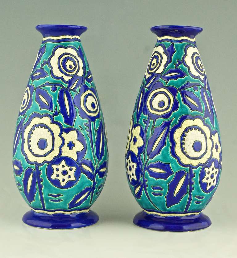 A pair of Art Deco turquoise, blue and white craquelé vases with flowers. 
By Boch Freres Keramis. Belgium. 

Signature / Marks:  
Keramis stamp.  
Numbered D1425 for the decor.
942/2 proof that it is an original pair. 
 
Style:  Art