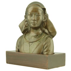 Antique bronze bust of an Asian girl in traditional costume.