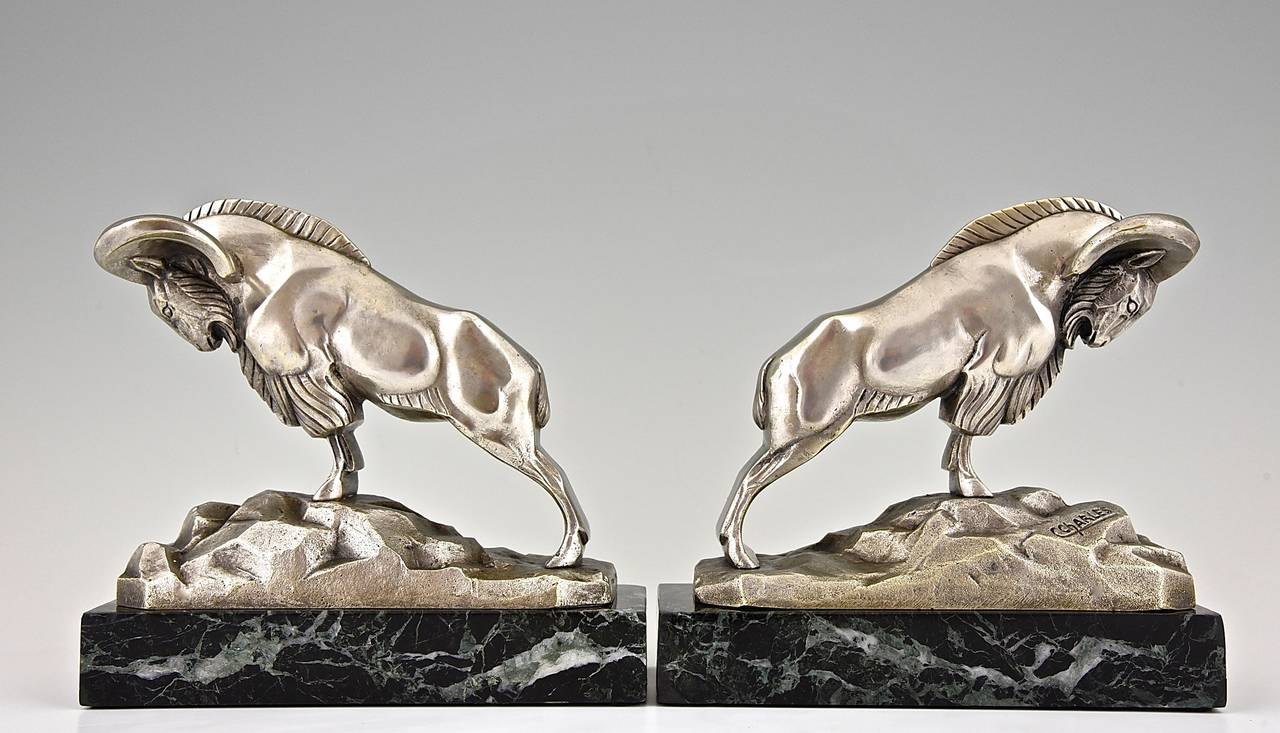 Description:  Art deco bronze ibex bookends.
Artist / Maker:  Charles, Charles.
Signature / Marks:  C. Charles. Patrouilleau fondeur.
Style:  Art Deco.	
Date:  Ca. 1930
Material:  Bronze with silver patina on green marble base. 
Origin: