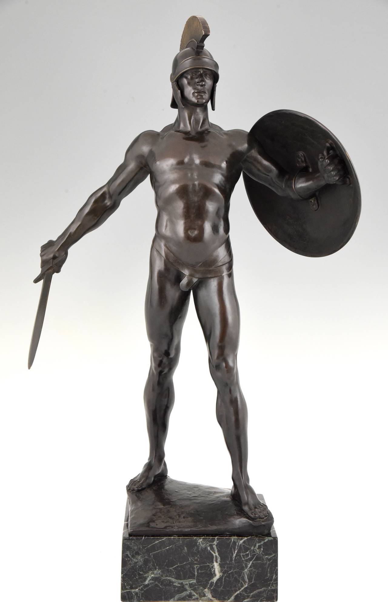 Art Deco bronze male nude sculpture of a sword fighter. 
Artist/ Maker:  Karl P. Kowalczewski. 
Signature: Kowalczewski. 
Style:  Art Deco.		
Date:  1924.		
Material: 
Bronze with very dark brown, almost black patina. 
Gilt feathers on the