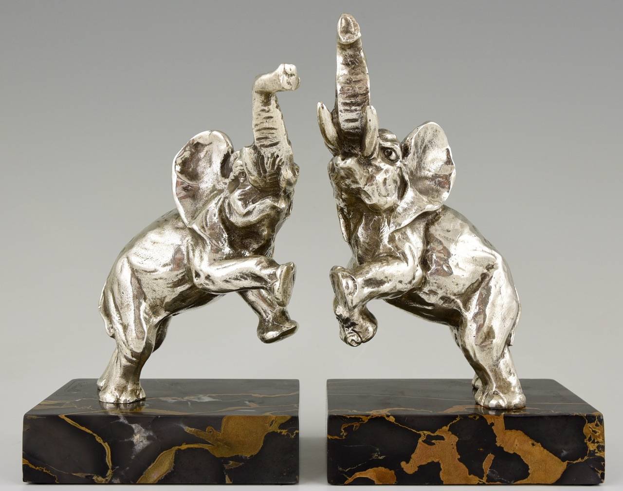 Description:  Art Deco silvered bronze elephant bookends.
Artist/ Maker:  Jean de la Fontinelle.
Signature/ Marks:  L. Fontinelle. 
Style:  Art Deco. 
Date:  1930. 
Material:  Silvered bronze.  Portor marble base. 
Origin:  France. 
Size of