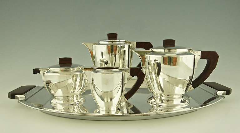 A 5 piece Art Deco tea and coffee set by Gallia, Christofle. 
Signature & Marks: 
O. Gallia. 
Christofle mark. 
Each piece is stamped and numbered.

Style:  Art Deco. 		
Date:  1930. 			
Material:  Silver plated metal.  Wooden