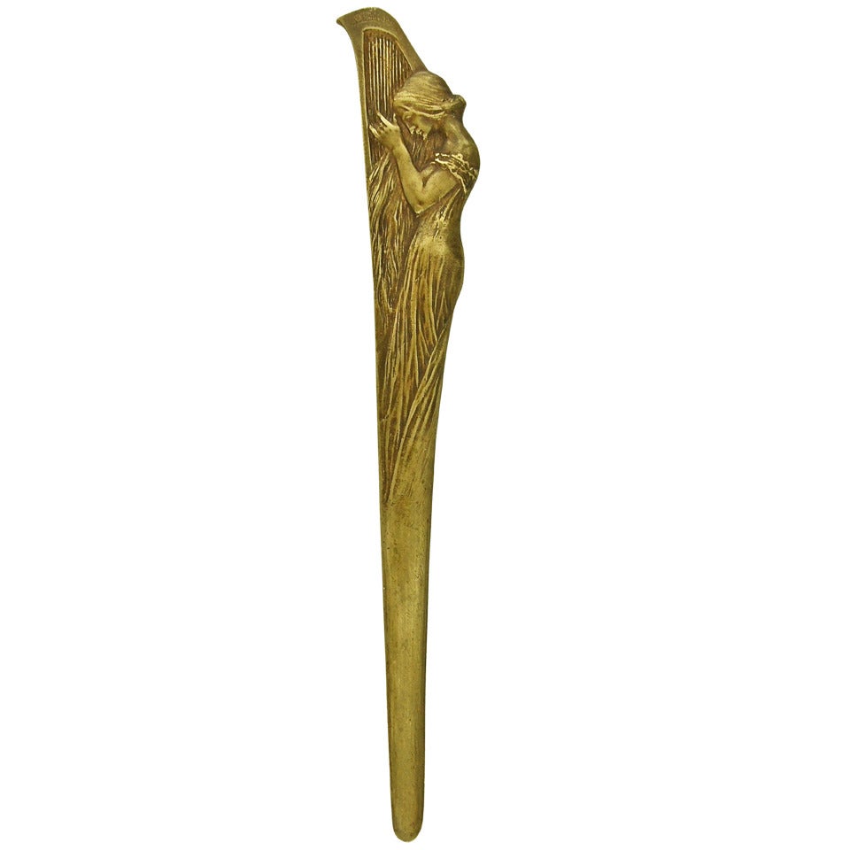 An Art Nouveau bronze letter opener with maiden playing a harp.