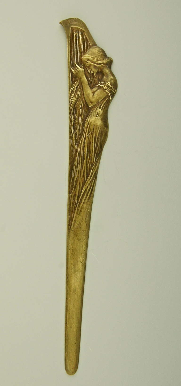A letter bronze opener with Art Nouveau maiden playing a harp.  
Style:  Art Nouveau. 
Condition:  Good original condition.  
Date:  Ca.1900.
Material:  Patinated bronze.
Origin:  France. 
Size:  
L. 31.5 cm. x W 4.5 cm. 
L. 12.4 inch x W.