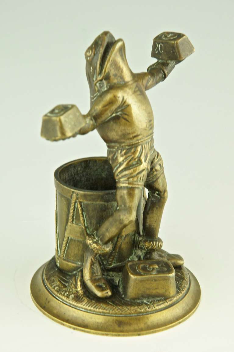 Bronze of a frog lifting weights signed by Malide. 
The drum behind him can be used for matches or toothpicks.
	
Size: 
H. 5.7 inch x L. 4.5 inch. x W. 3.5 inch.  
H. 14.5 cm. x L. 11.5 cm. x W. 9 cm.  

Fedex shipping: $ 75