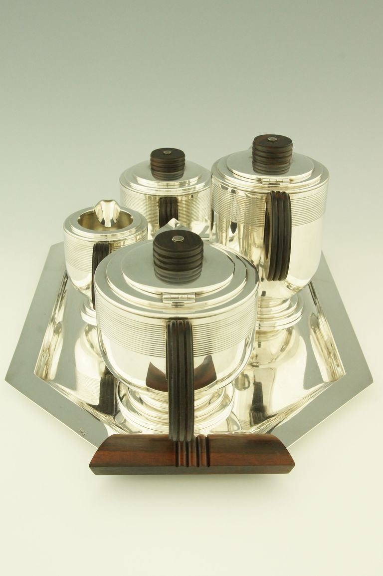 A 5 piece silver plated Art Deco tea and coffee set with Macassar wooden handles by Roux Marquiand. Lyon, France 1930. 
Each piece is stamped and numbered. 

Fedex shipping: $ 245.

Literature:
Dictionnaire des poinçons, Orfèvrerie. 