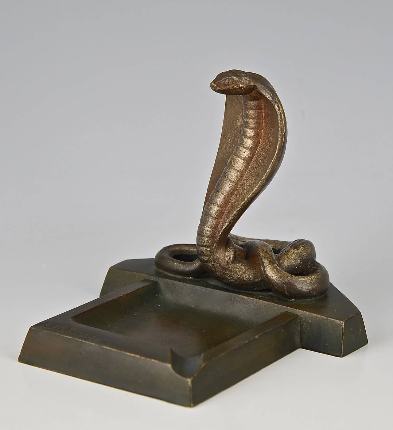 Art Deco cobra ashtray. 
By  A. Pichegru. 

Style: Art Deco.
Date: circa 1930.
Material: Patinated metal. 
Origin: France.

Size: 
H. 3.7 inch x L. 4.7 inch. X W. 3.9 inch.
H. 9.3 cm x L. 12 cm. x W. 10 cm. 
Condition:  Good original