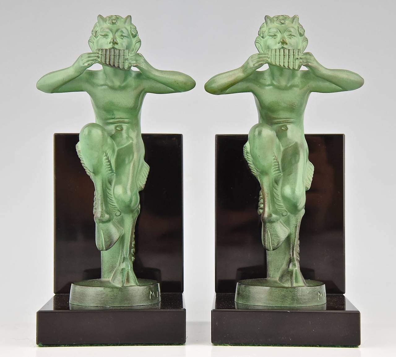 A pair of Art Deco satyr bookends signed Mic.
Cast by the Max Le Verrier foundry.
Style: Art Deco. 
Date: 1925-1930.

Material:  Green patinated metal. Black marble base. 
Origin:  France. 

Size of one:  
H 7.3 inch x L 3.9 inch x W 3.1