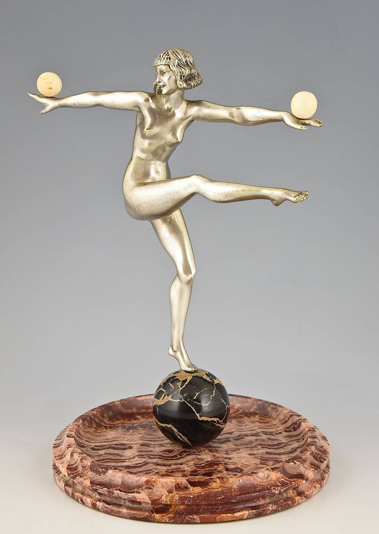 Art Deco bronze sculpture of a nude dancer by Pierre Le Faguays.
Signature: Le Faguays on the marble ball. 
Style: Art Deco.
Date:  circa 1925-1930.

Material: Silvered bronze.  Marble tray. 
Origin:  France. 
Size:
 H. 12.8 inch x L. 9.4