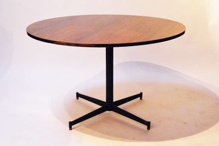 Pedestal table by Ignazio Gardella, circular walnut table top, resting on a cruciform metal feet with black paint finish.