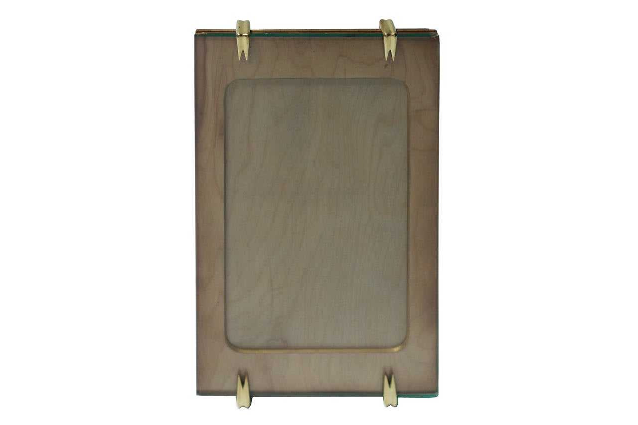 Set of four wood picture frames with brass clasps and glass front.