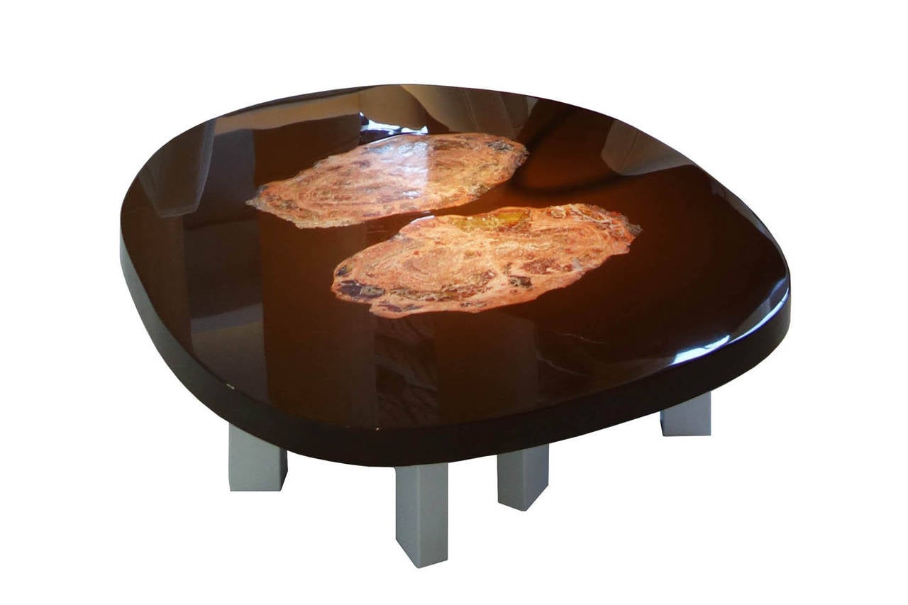 Beautiful coffee table by Ado Chale, tabletop in resin with petrified wood slabs inlay. Tabletop resting on four tripod metal feet. Signature in brass on the side of the tabletop.