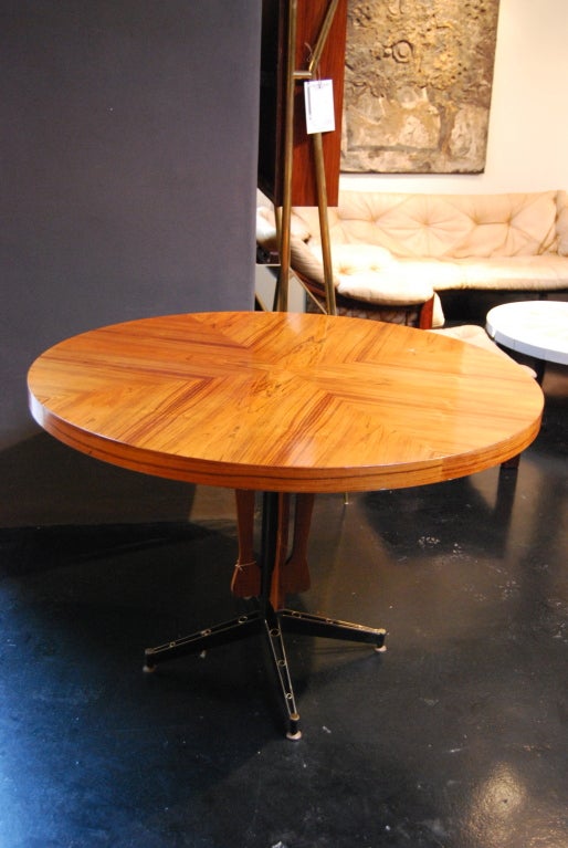 Table made of 4 walnut sheets joined in its centre giving a beautiful cross drawing. 

The foot is divided in four ends decorated with circles.