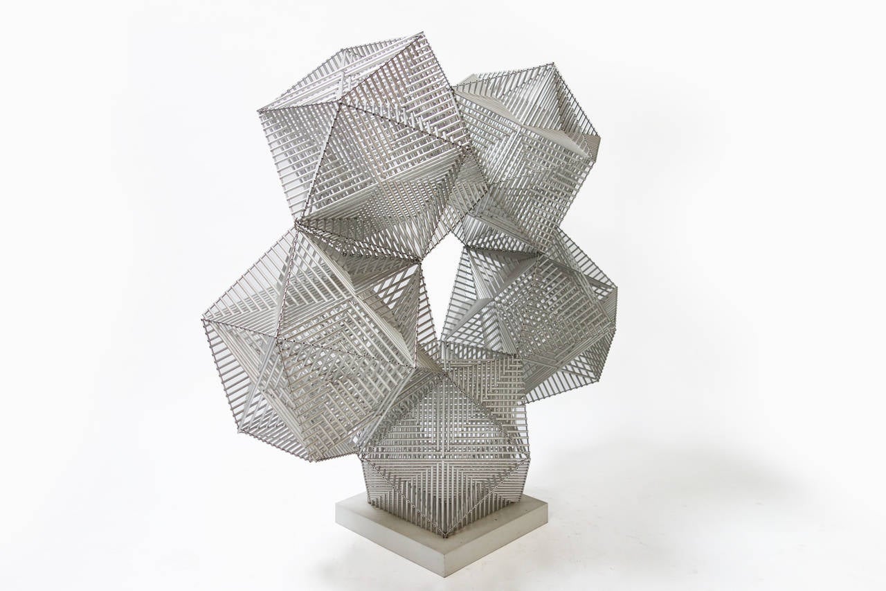 Konstruktion - arkimediska kroppar (Archimedes cell) sculpture of interwoven aluminum tubes on a metal base.