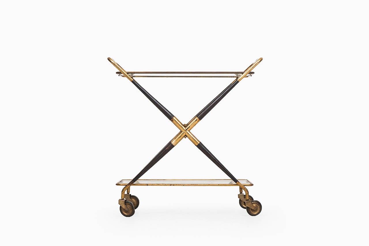 Foldable trolley bar cart Cesare Lacca, with blackened wood structure and brass details.

Original glass plate.