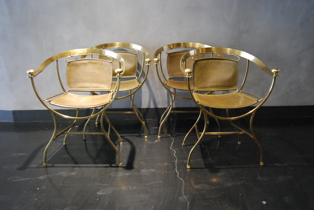 Four brass chairs with dark green leather. The leather is very thick and of good quality. Sawed together. The brass gives a royal effect to its original design. They are very heavy but mainly comfortable.