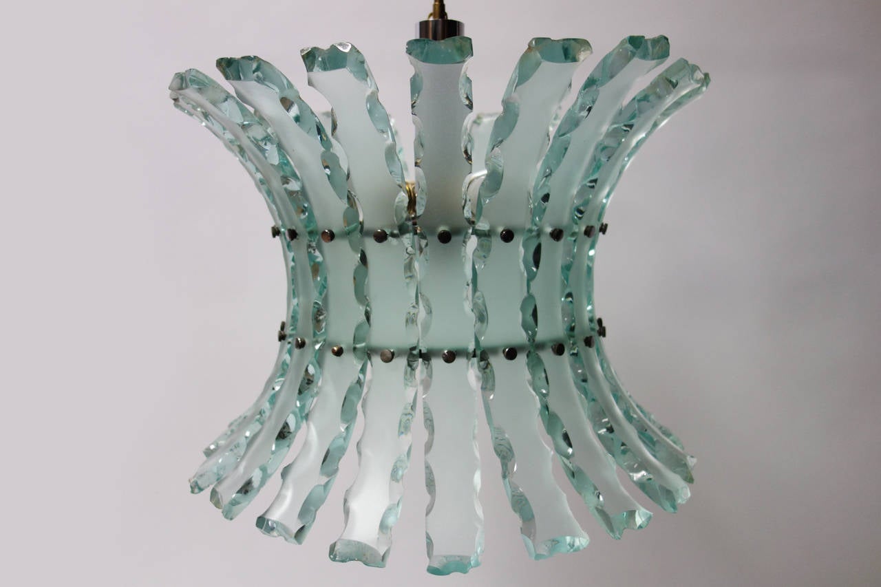 Fantastic Italian hanging fixture in the style of Fontana Arte.
Chandelier composed of sanded crystal curved blades with chipped edges,
attached to a chrome-plated backplate by elegant screws.

Original wiring, takes four 40W with candelabra