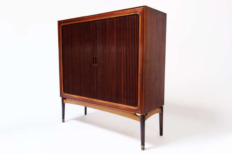 Danish rosewood dresser, with sliding roller doors, inside oak shelves and drawers, brass details on the legs.