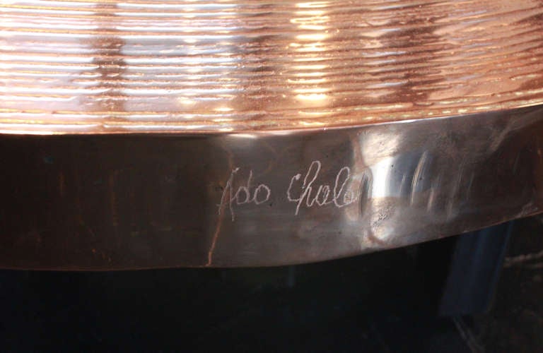 Bronze table top with ripples.

There's more copper in the alloy of this table top than usually, wich reflect light with a pink hue.

Table top restins on three tripod metal feet.

Table top signed by Ado Chale.

Authenticity certificate
