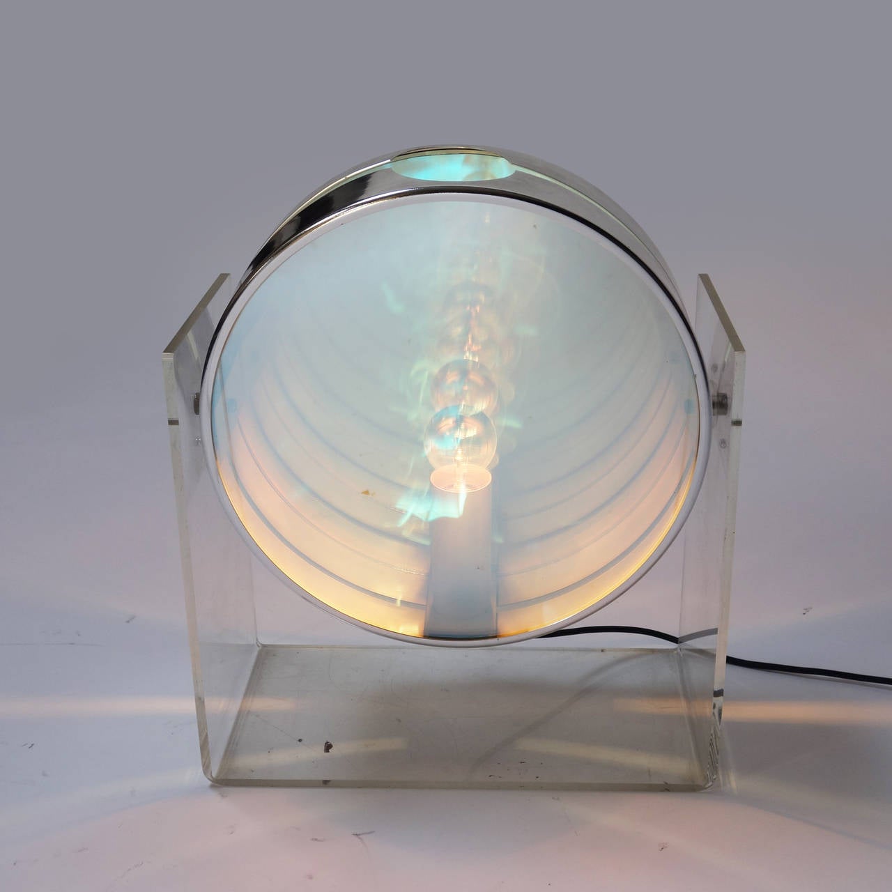 Table lamp featuring an acrylic structure with double-sided mirror case and chromed metal fittings. 

Once turn on, the light create a infinite tunnel effect.