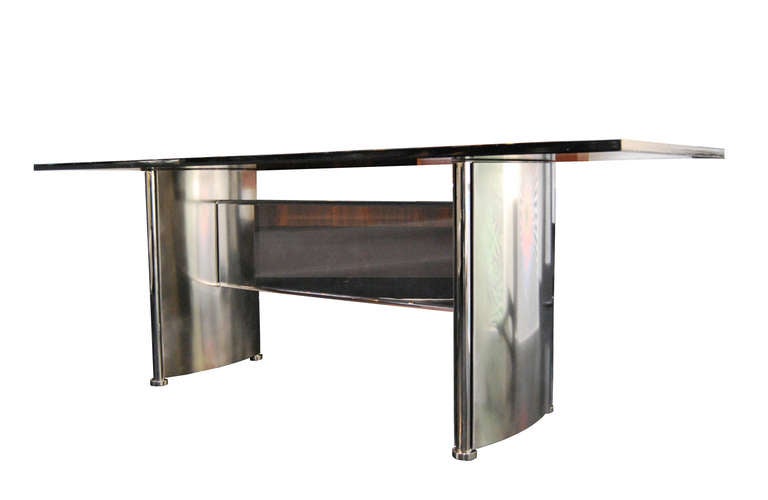 Lacquered desktop resting on polished steel and perspex legs.