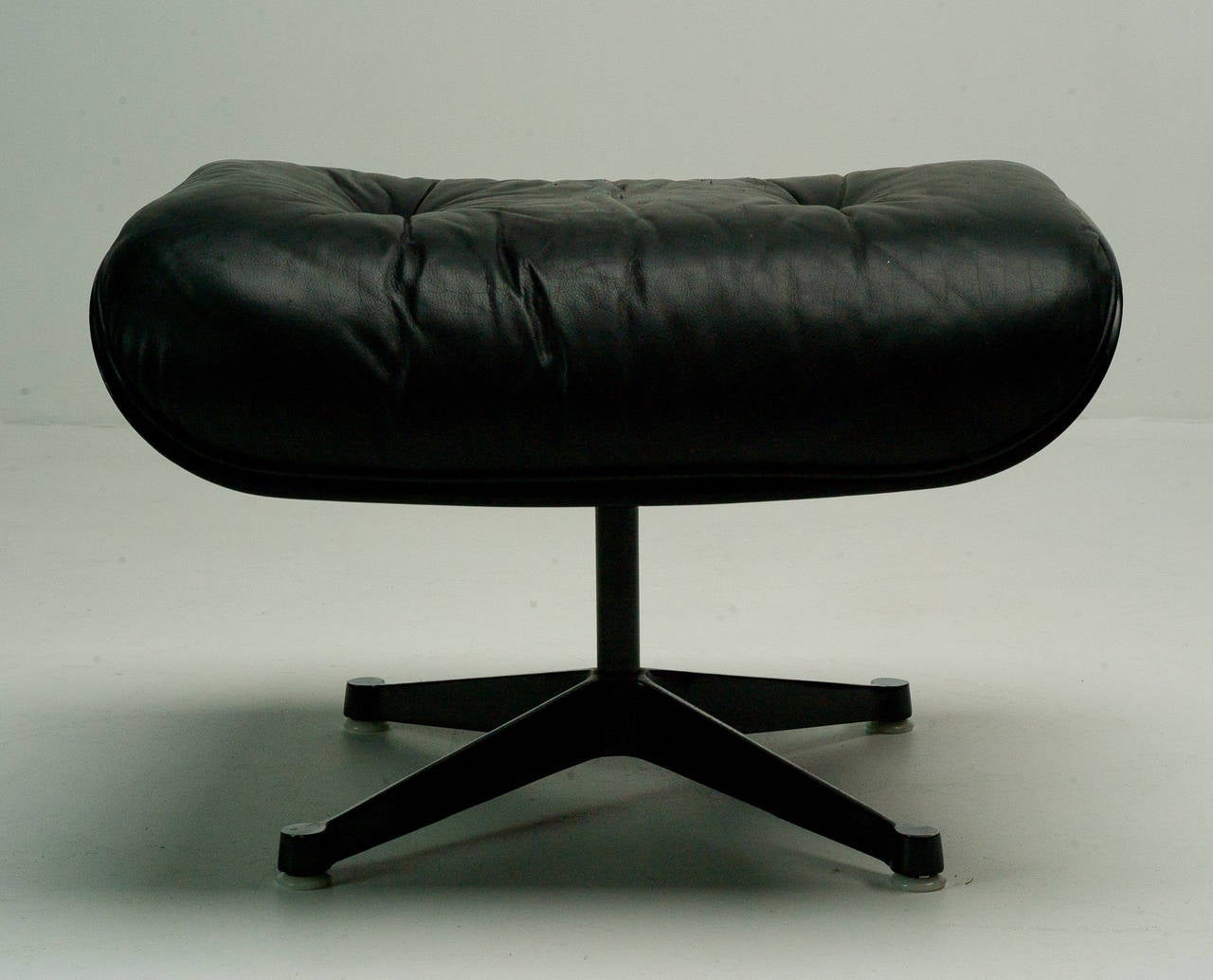 Black leather, black shell ottoman with polished aluminium base by Charles Eames for Herman Miller and Vitra.
