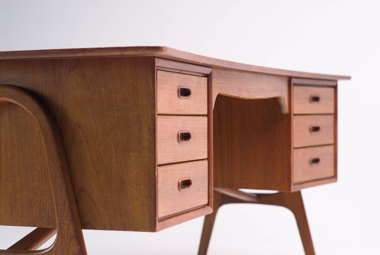 Danish modern teak executive desk with bow tie lip front edge and curved top. Features six drawers and an open bookshelf and is perfect for any modern home or office.
Competitive worldwide shipping available. Please ask for our in-house crating and