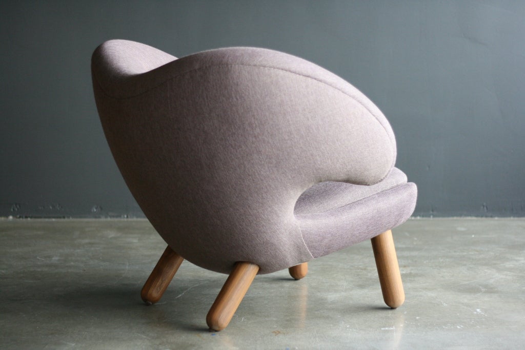 Beautiful Danish craftsmanship, elegance and great comfort come together in this Pelican or FJ 4001 armchair. Purple/taupe colored woolen upholstery with walnut legs.
This is a recent, One collection, model.