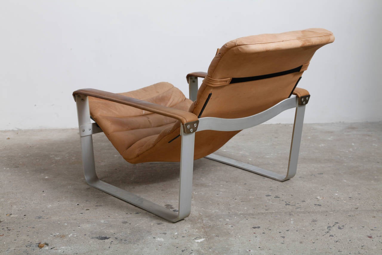 A set of two Ilmari Lappalainen lounge chairs, Pulkka,1963, made by Asko.
Aluminium base and 1light and 1dark brown leather,adjustable seat in three positions.