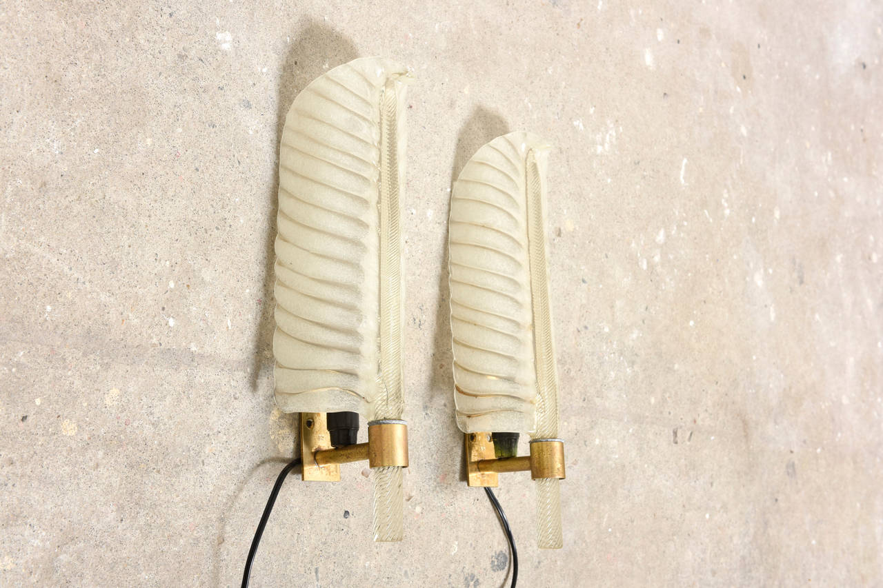 Two pair of Barovier e Toso feather shaped sconces. 

These single lights, in a feather design, Pulegoso glass and brass gilt mounts designed by Barovier e Toso, 1950s, Murano, Italy.
Measure: 1 set H 40 cm, W 13 cm, D 10 cm.
1 set H 31 cm, W 12