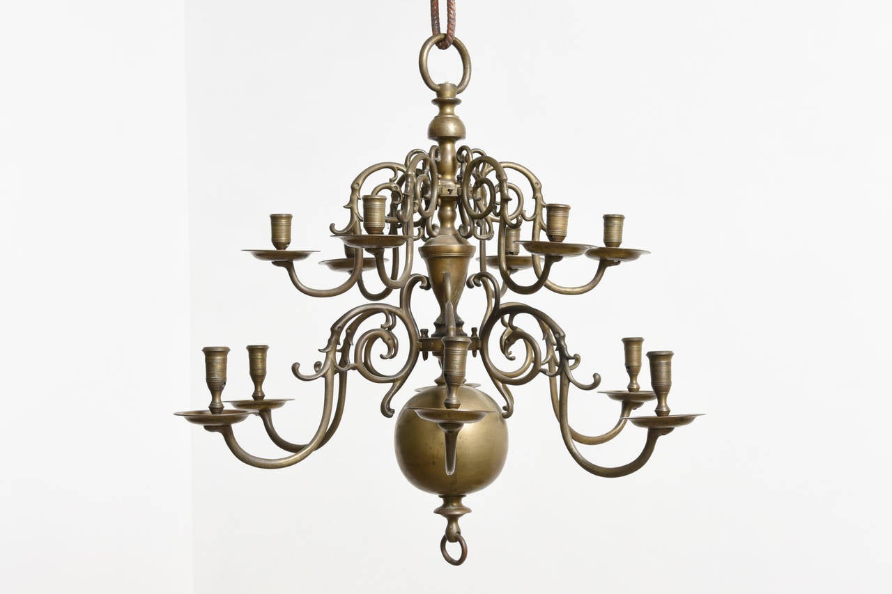 A bronze chandelier with twelve arms pinned and numbered removable arms. Height 65 cm,diameter 65 cm.

Dutch Baroque,late 18th century. 

In the 20th century they adjusted this chandelier with electricity,the bronze dishes pierced for the