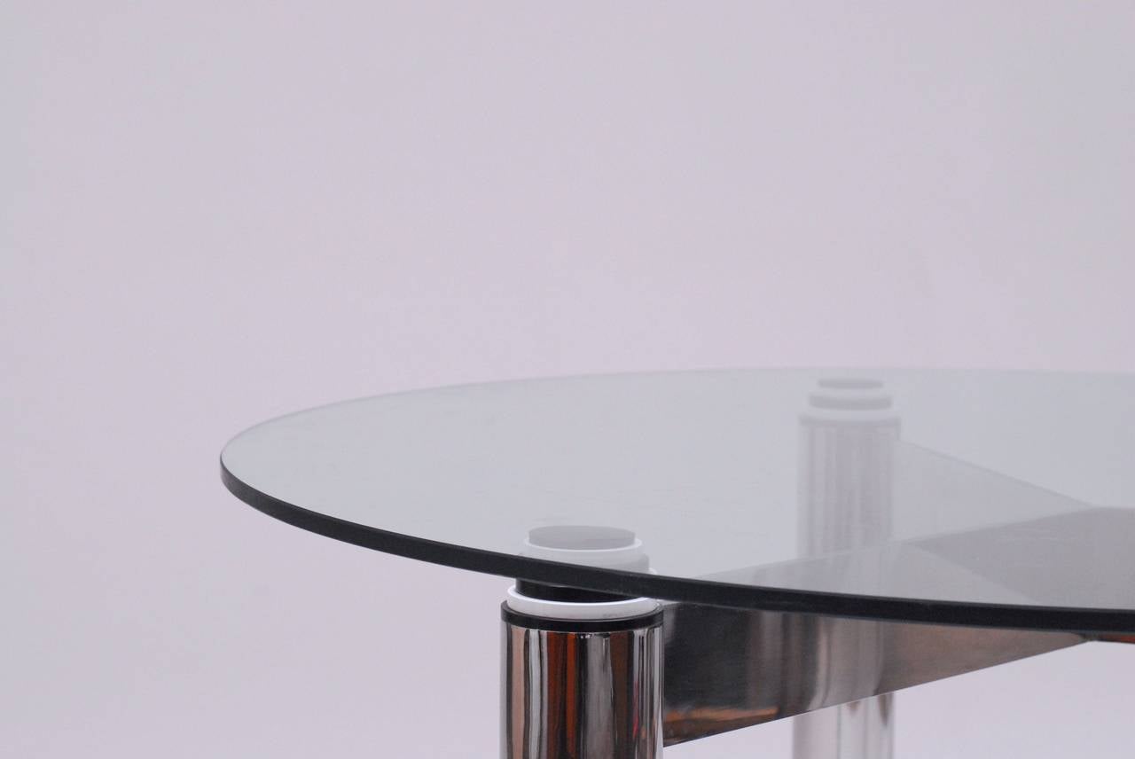 Chromed steel round table with resonating extremes at the end of it's legs. This table has a powerful look due to it's choice of material. The effect of the black and with extremes give a light, almost bouncing feel.