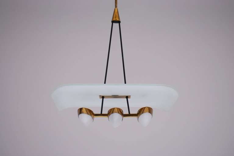 Superbe elegant chandelier with great sculptural features. It seems an abstraction of either a bird or a seaplane.
The proportions are discrete, compact but yet powerful.
3 hand welded brass frames holding 3 perspex shades. Above that there is a