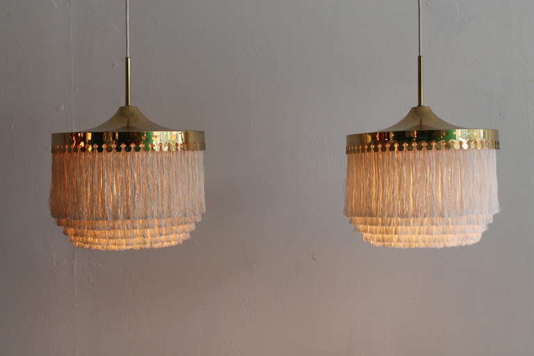 A very unusual pair of Hans Agne Jakobsson ceilinglamps in Brass and fabric tassels.
Solid brass and  tassel shade.

very good original conditon 
signed 
also wired for US use , adjustable in height