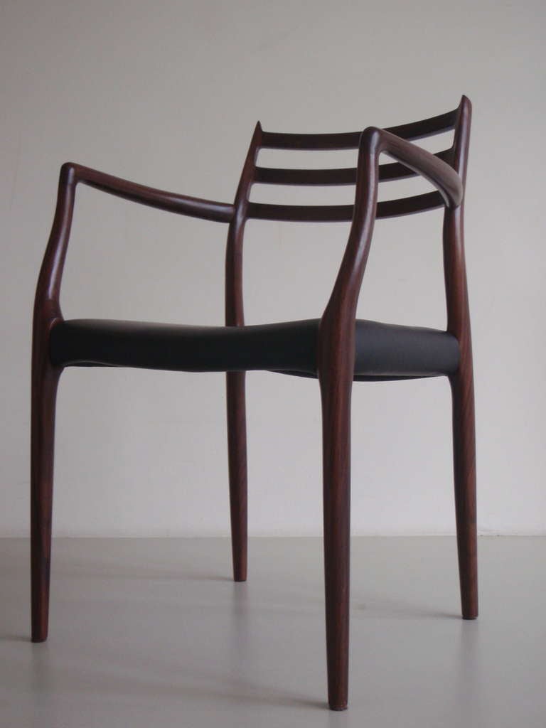 Extraordinary dark rosewood arm chair by Niels O. Moller with black leather upholstery. Beautiful crafted piece that's stunning from every angle. Excellent dining chair (if you desire more pieces please contact us) but works just as well a desk or