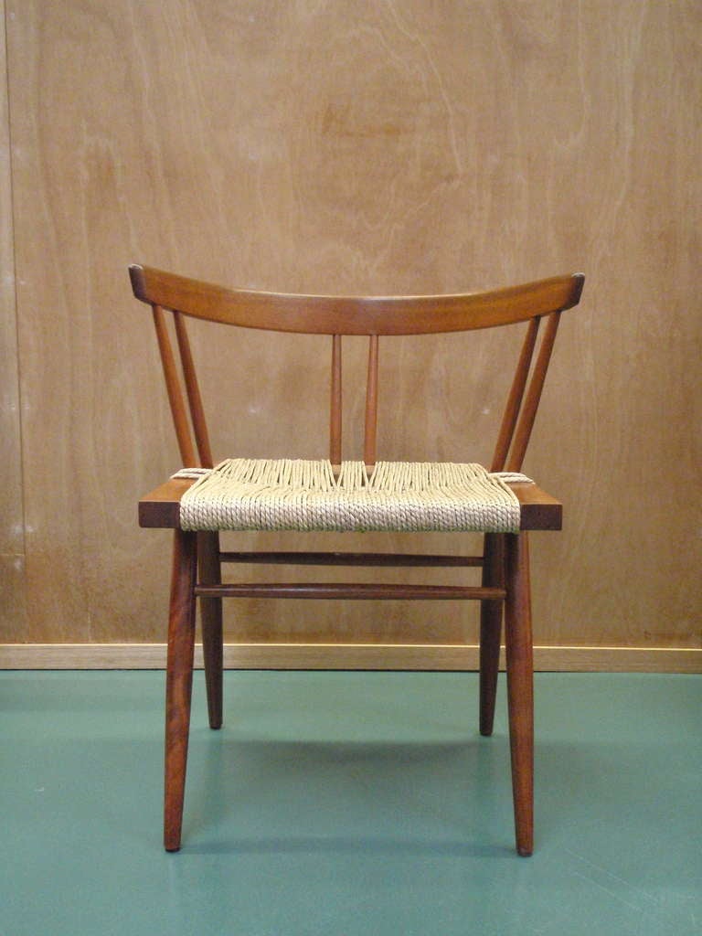 Grass seat chairs by George Nakashima, circa 1950's.  
Walnut seat, frame and back rail supported by four tapered legs with natural grass caning woven over seat frame. 
Two chairs available. Priced individually.  