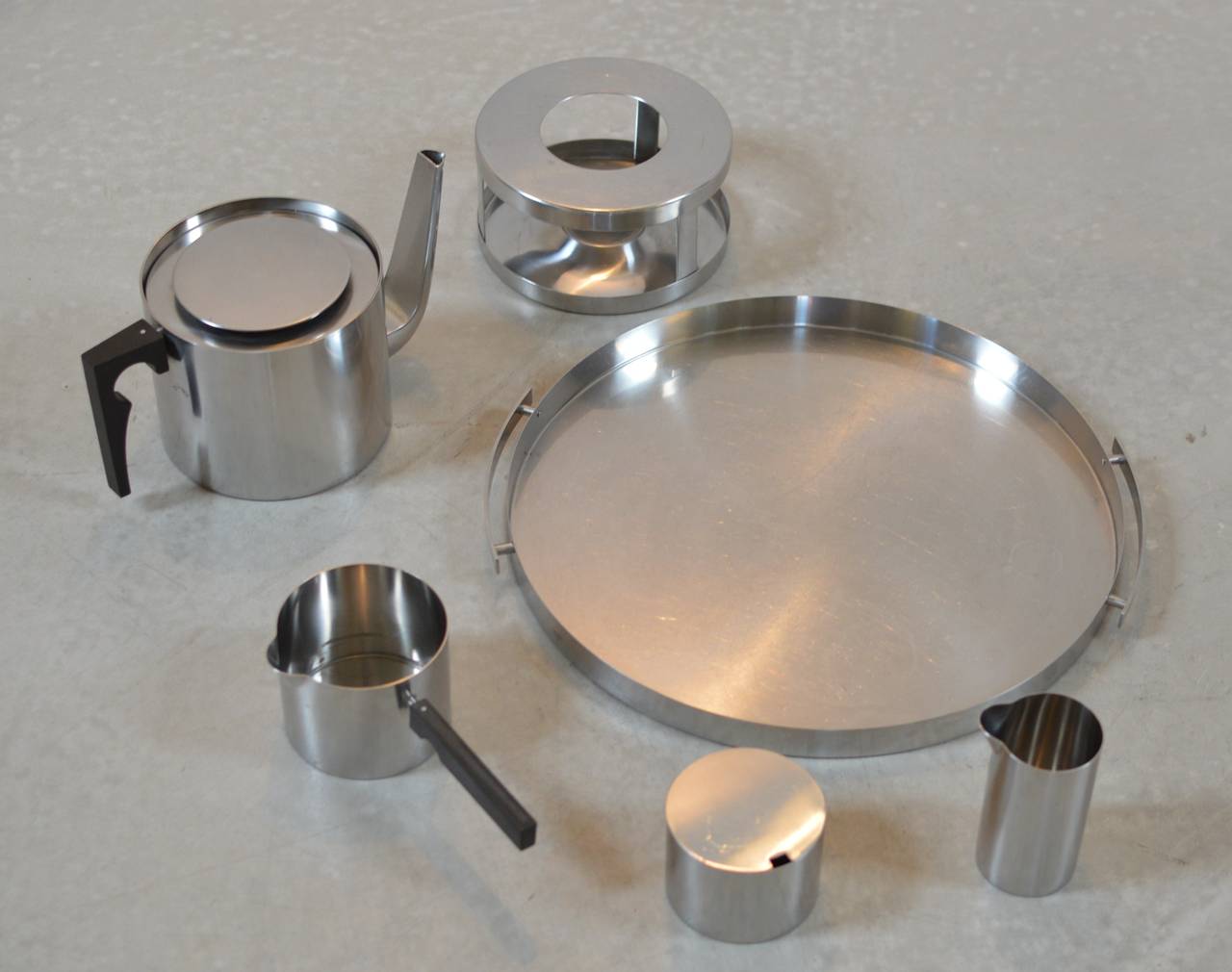 Complete Cylinda Line stainless steel tea service, designed in 1967 by Arne Jacobsen manufactured by Stelton Denmark consisting of:
1 large round serving tray with handles. 14.13