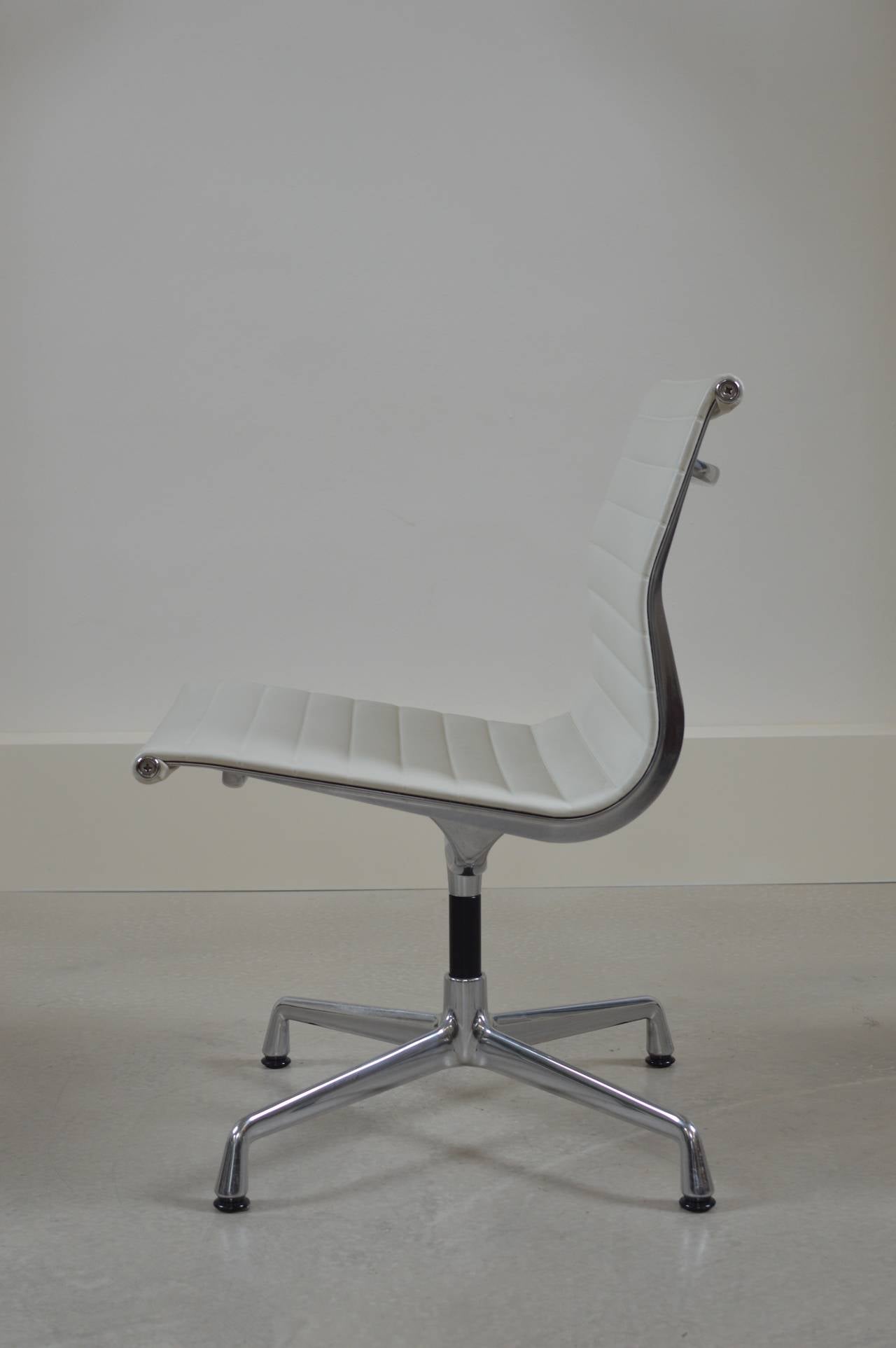 White leather EA105 chair by Charles & Ray Eames with a chromed four-legged base with felt floor glides. Originally designed in 1958, the chair is from a more recent production, a Vitra edition as signed and shown on last photos.