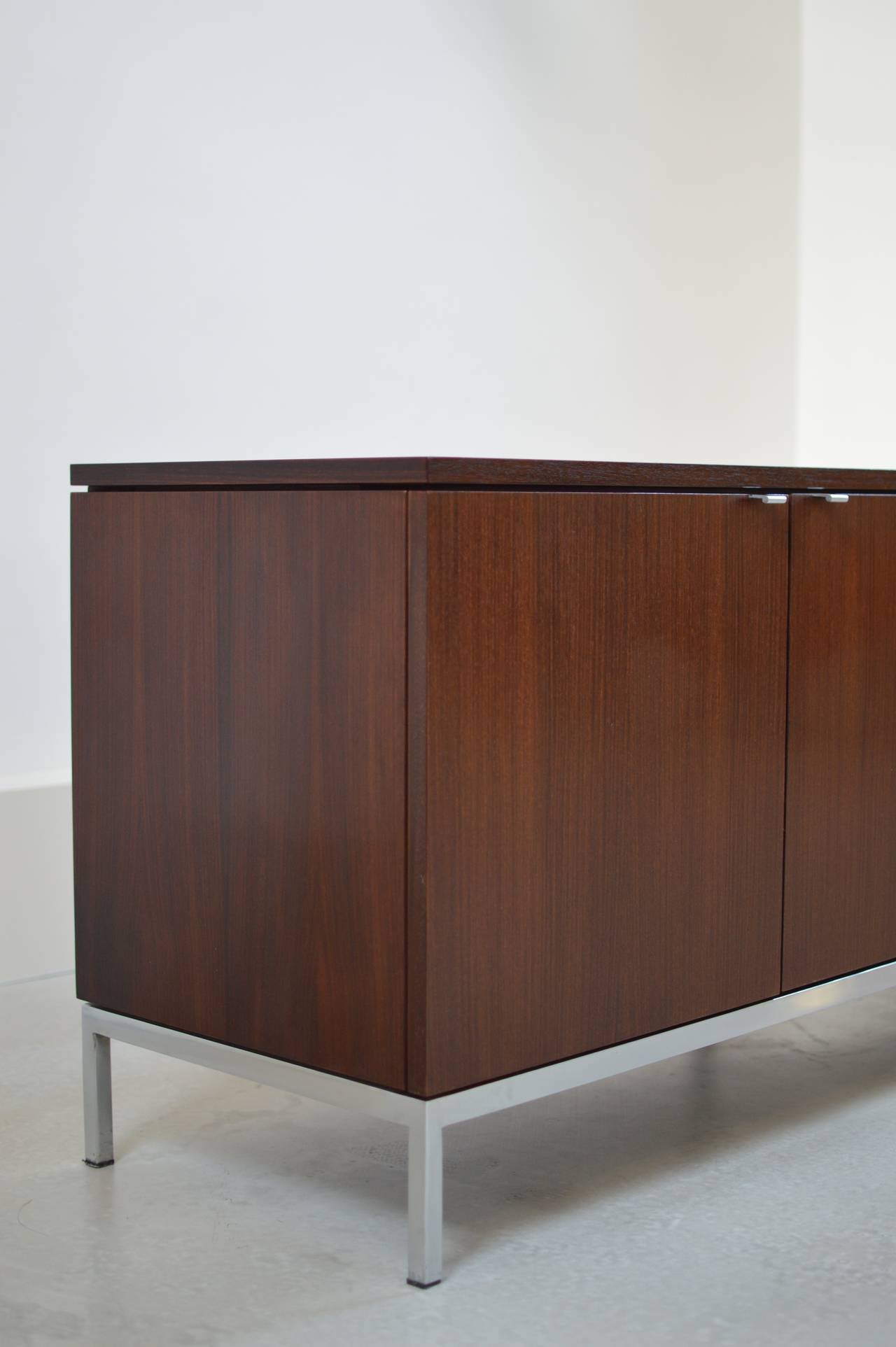 Four-door credenza by Florence Knoll in rich dark brown mahogany with plain pulls on beautiful seamless base. 
Early 1960s example. Comes with original manufacturer's label.