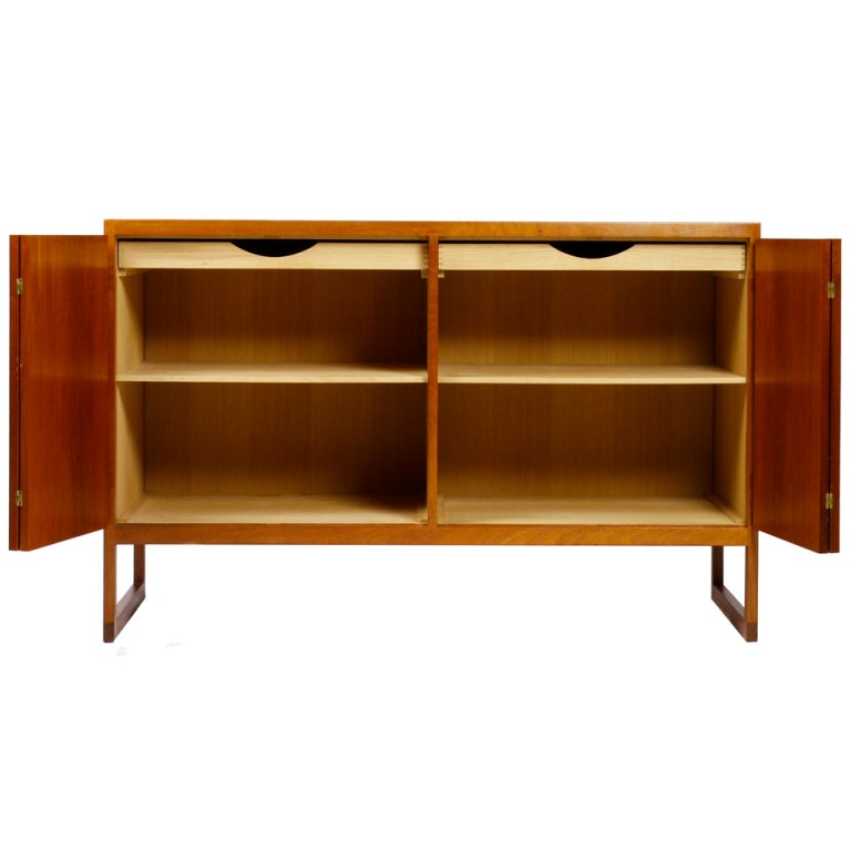 Beautiful BM57 cabinet by Børge Mogensen, designed in 1957.
The cabinet is executed in primarily solid teak and features two beautiful folding doors with brass fittings and hinges 
The cabinet comes in wonderful condition with an extraordinary
