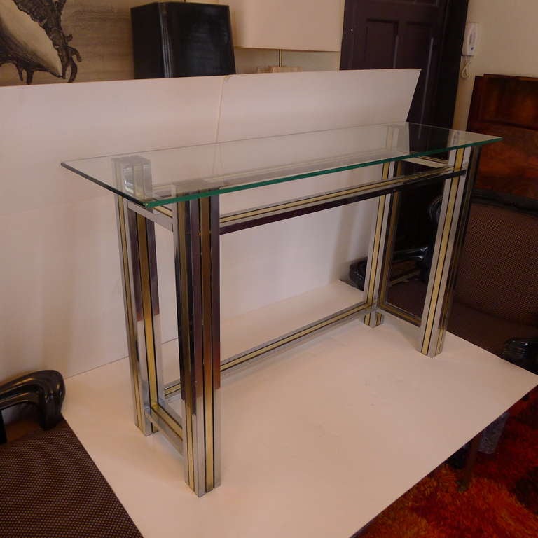 A console in chomed metal and brass with glas tabletop