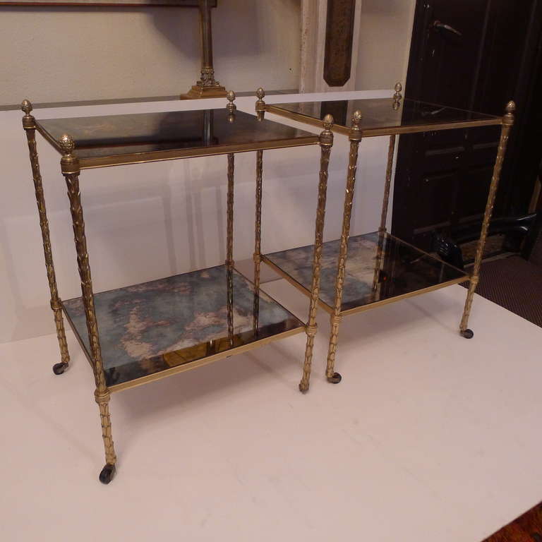 a pair of two tier side tables in bronze with patined mirrors shelves.