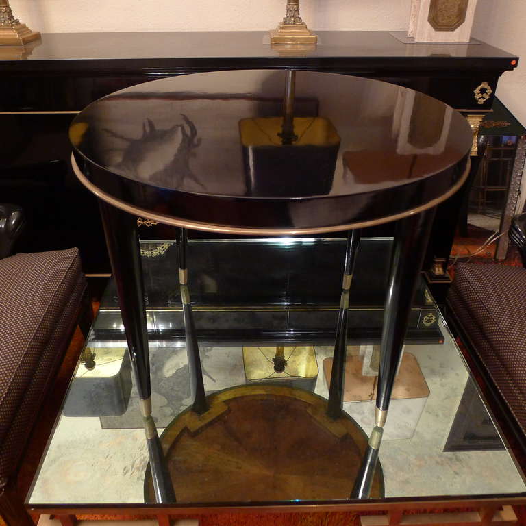 a black ebonized round coffee table with bronze details