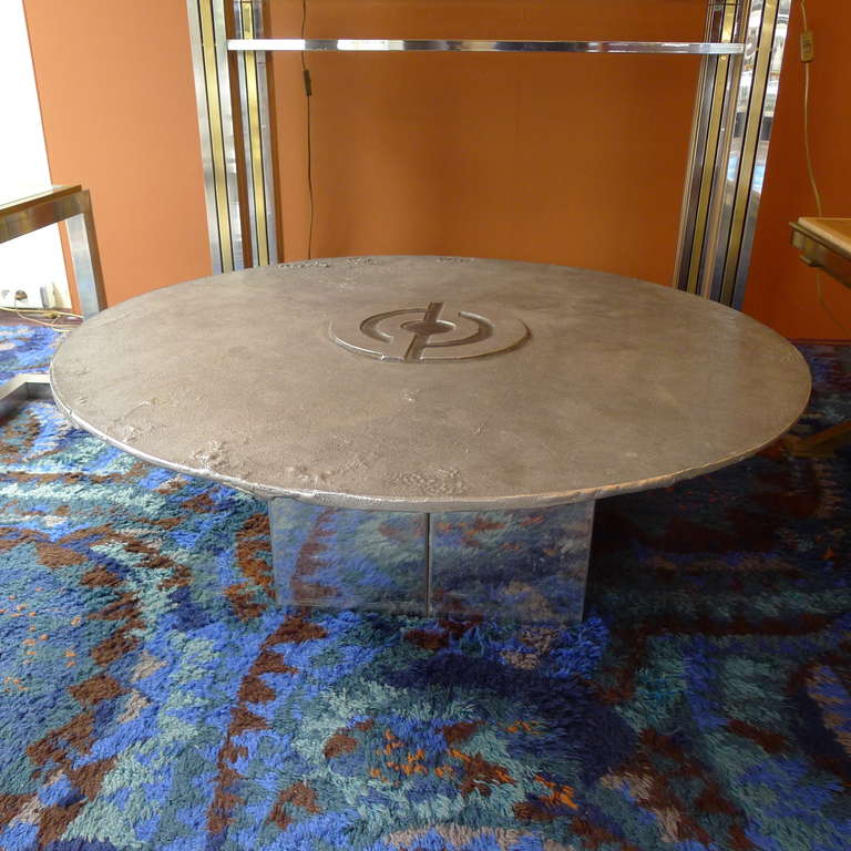 A round cast steel coffee table with a chromed metal base.