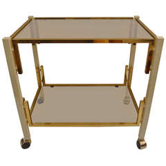 a two tier bar cart with bronze and lacquered ivory white details.